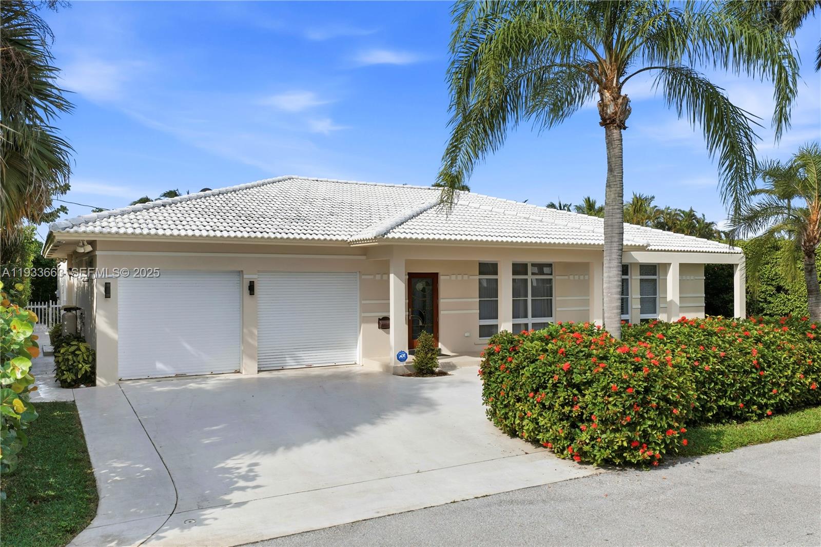 A single-story house with a white tiled roof, two garage doors, and a palm tree — 2607 Holy Cross Ln, Lake Worth FL 33460, LAKE WORTH, FL