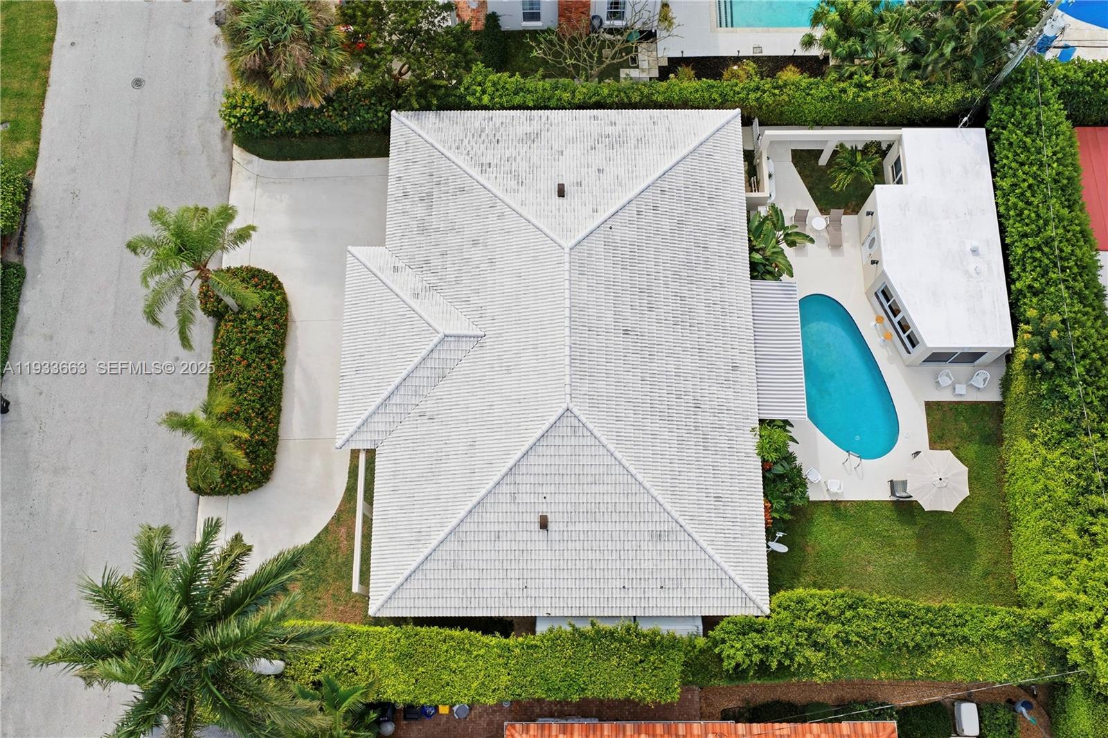 An aerial view shows a house with a white tile roof, pool, and landscaped yard — 2607 Holy Cross Ln, Lake Worth FL 33460, LAKE WORTH, FL