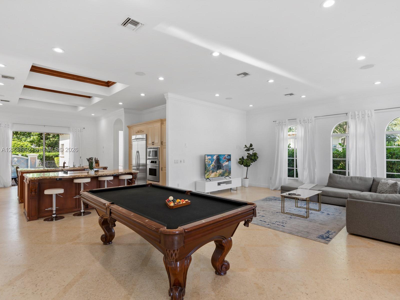 A spacious open-concept living area features a pool table, kitchen island, and gray sectional sofa — 1223 Jackson St, Hollywood FL 33019, HOLLYWOOD, FL