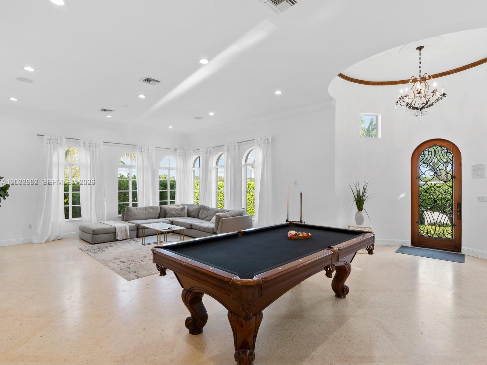 A spacious room features a pool table, a sectional sofa, and an arched wooden door — 1223 Jackson St, Hollywood FL 33019, HOLLYWOOD, FL