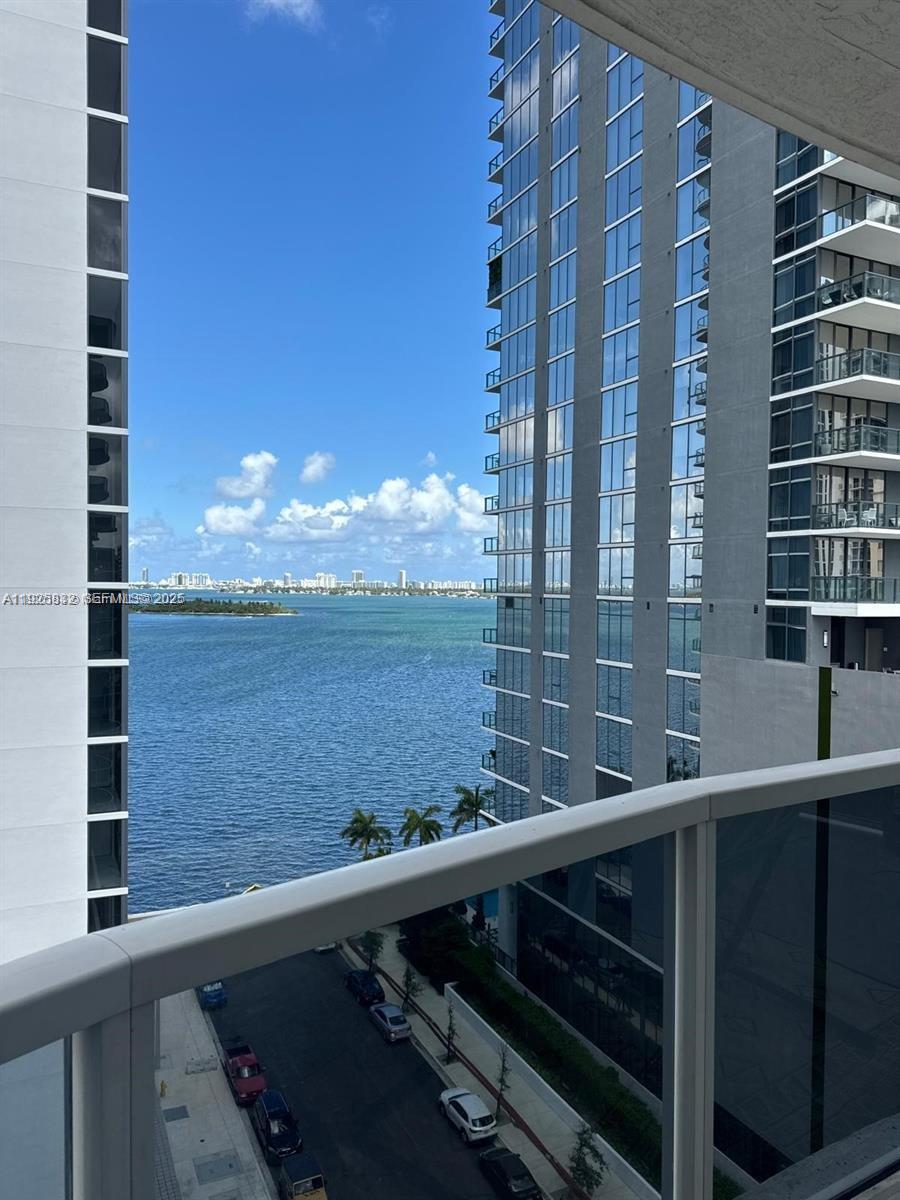 A balcony view overlooks a body of water between two high-rise apartment buildings — 601 NE 23 ST # 1103, Miami FL 33137, MIAMI, FL