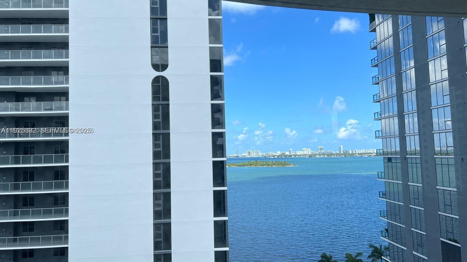 A view from a balcony shows a bay, a small island, and distant city buildings — 601 NE 23 ST # 1103, Miami FL 33137, MIAMI, FL