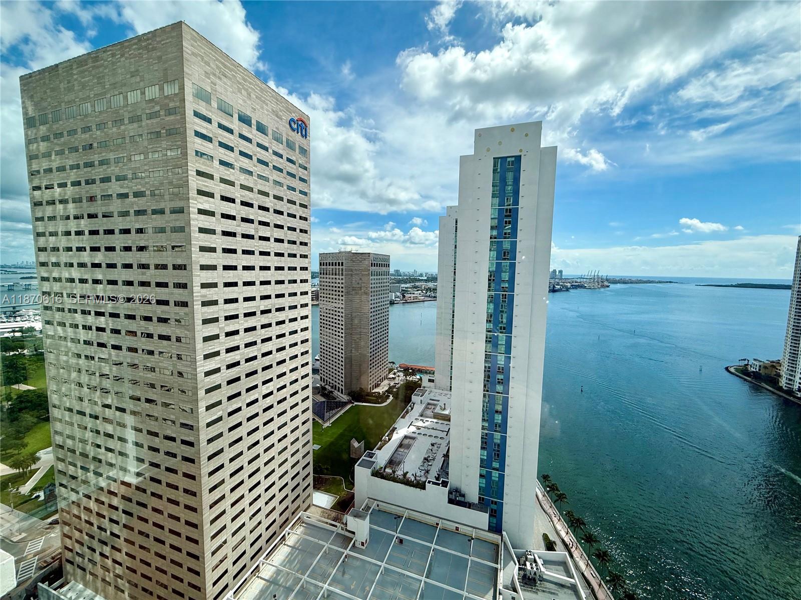 An elevated view shows several skyscrapers and a parking structure overlooking a bay — 300 S Biscayne Blvd # 3014, Miami FL 33131, MIAMI, FL