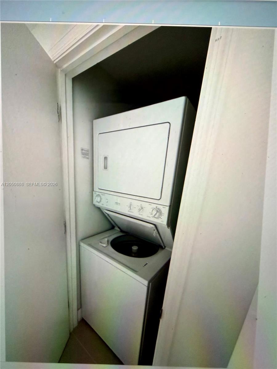 A white stacked washer and dryer unit is located inside a small closet — 500 Brickell Ave # 2003, Miami FL 33131, MIAMI, FL