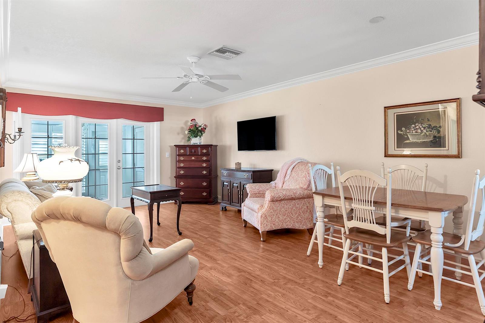 A living and dining area features light wood flooring, a ceiling fan, and traditional furniture — 2930 Crosley Drive E # M, West Palm Beach FL 33415, WEST PALM BEACH, FL
