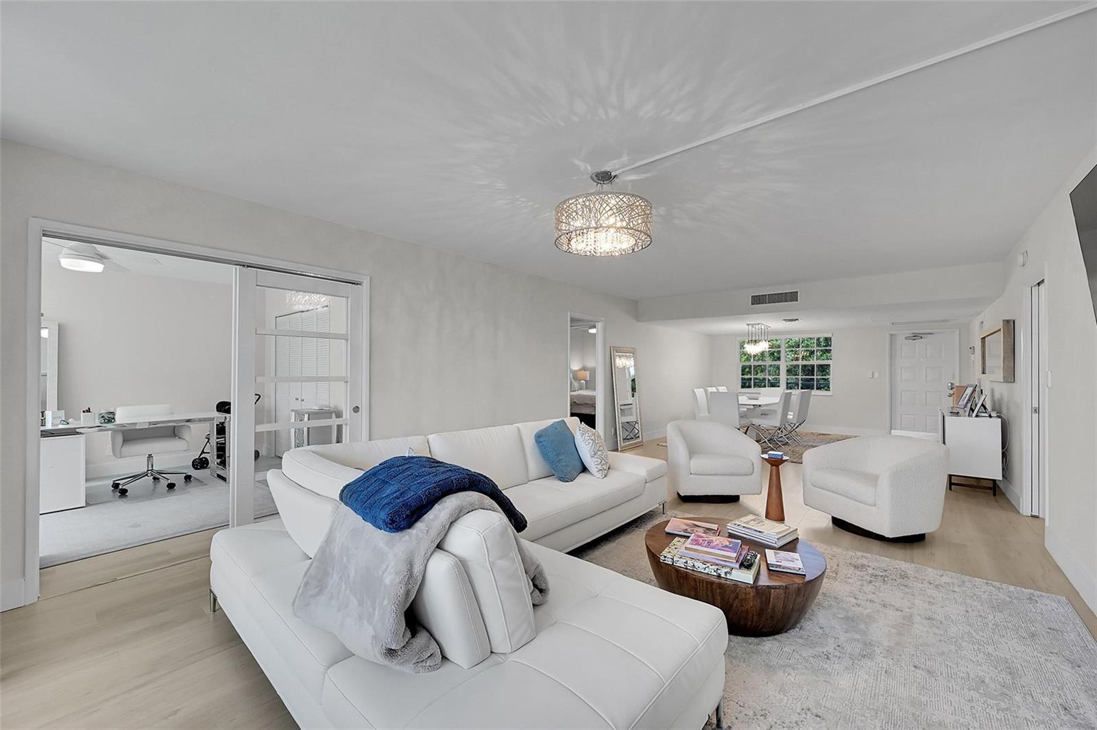 A bright living room features a white sectional sofa, two armchairs, and a coffee table — 555 Oaks Lane # 311, Pompano Beach FL 33069, POMPANO BEACH, FL