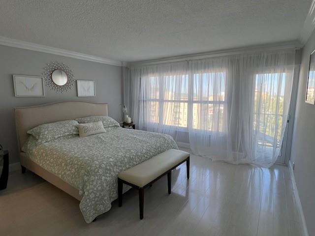 A bedroom features a king bed with a floral quilt, a bench, and floor-to-ceiling curtains — 405 N Ocean Boulevard # 825, Pompano Beach FL 33062, POMPANO BEACH, FL