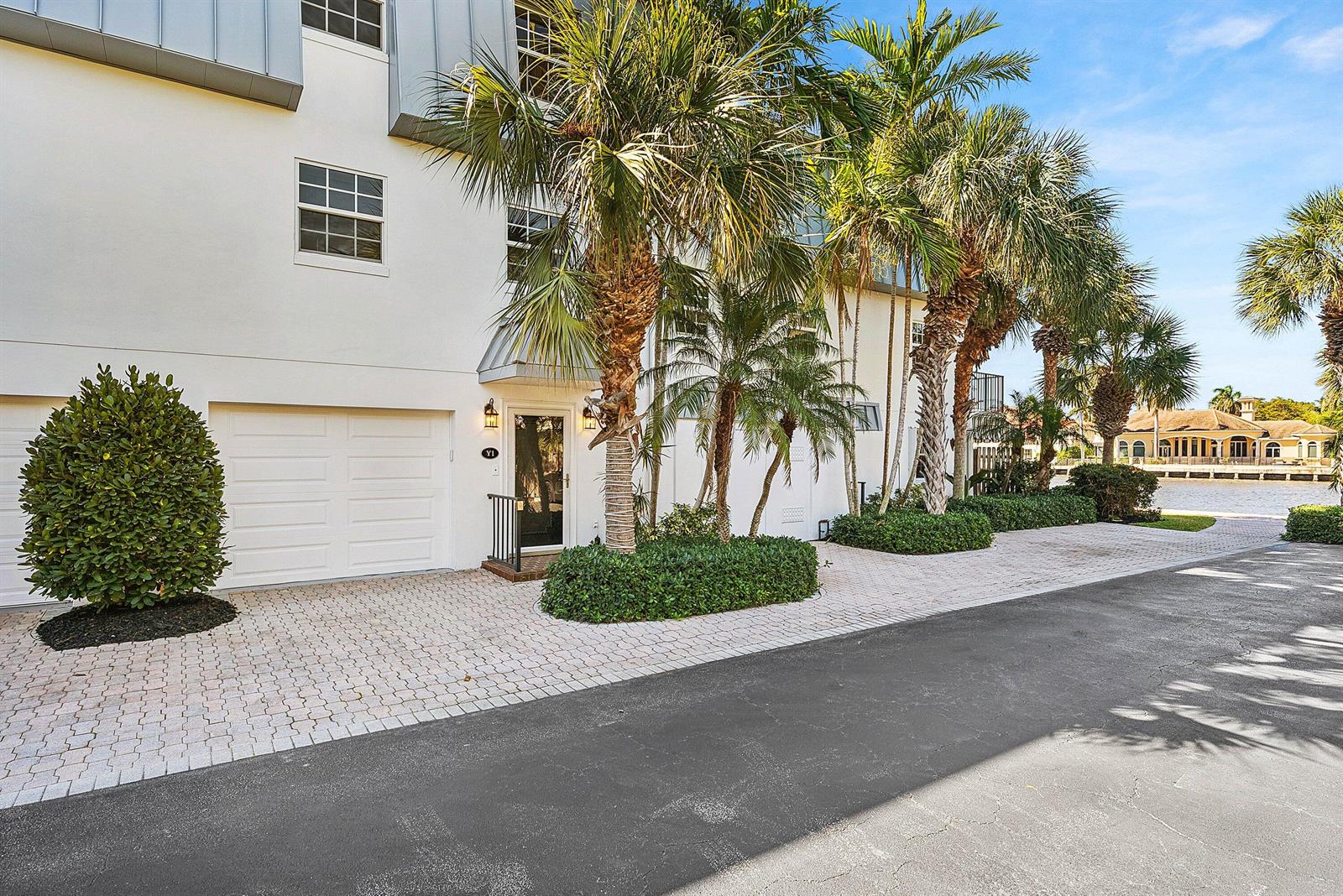 A white multi-story townhouse with a garage, palm trees, and a paved driveway — 2000 S Ocean Boulevard # Y1, Delray Beach FL 33483, DELRAY BEACH, FL