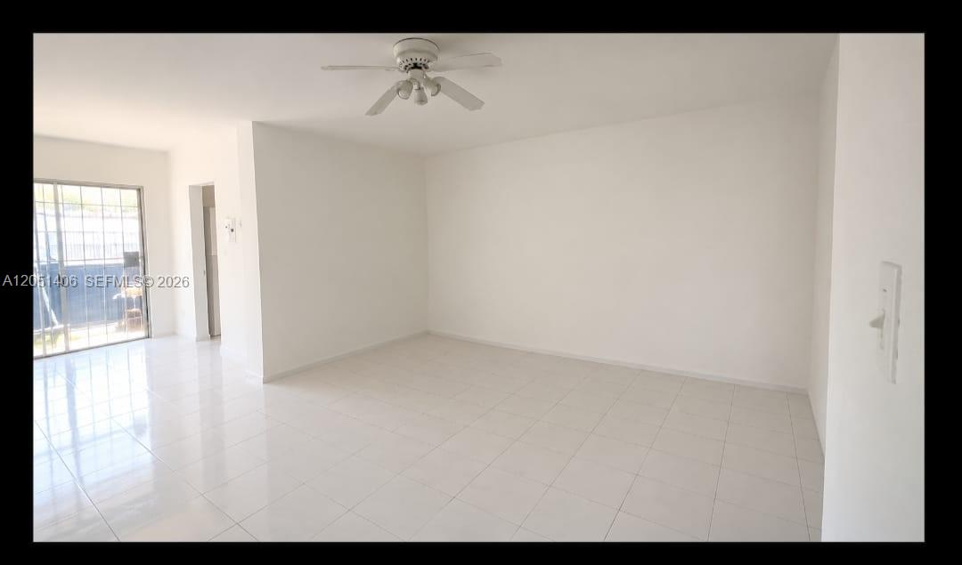 An empty room with white walls, white tile flooring, and a ceiling fan — 13500 NE 3rd Ct # 121, North Miami FL 33161, NORTH MIAMI, FL