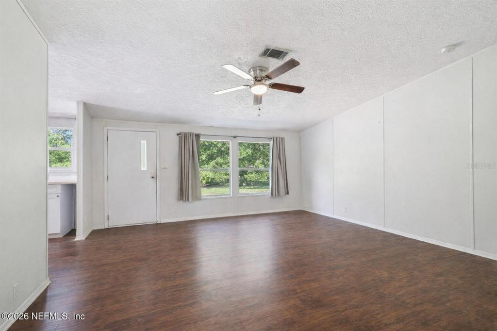 A living room features white walls, dark wood-look flooring, and a ceiling fan — 14070 JOHN WILLIAMS ROAD, SANDERSON, FL