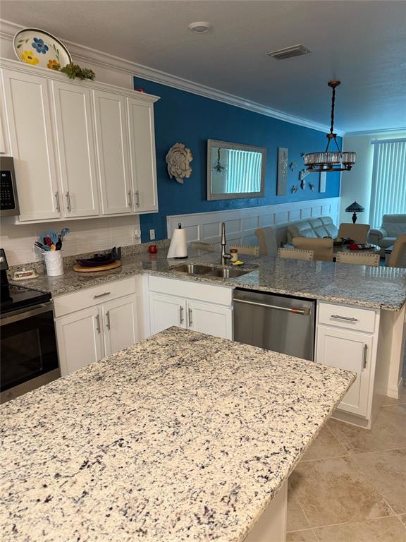 A kitchen features white cabinets, granite countertops, a stainless steel dishwasher, and a blue wall — 14061 HERITAGE LANDING BOULEVARD UNIT 443, PUNTA GORDA, FL