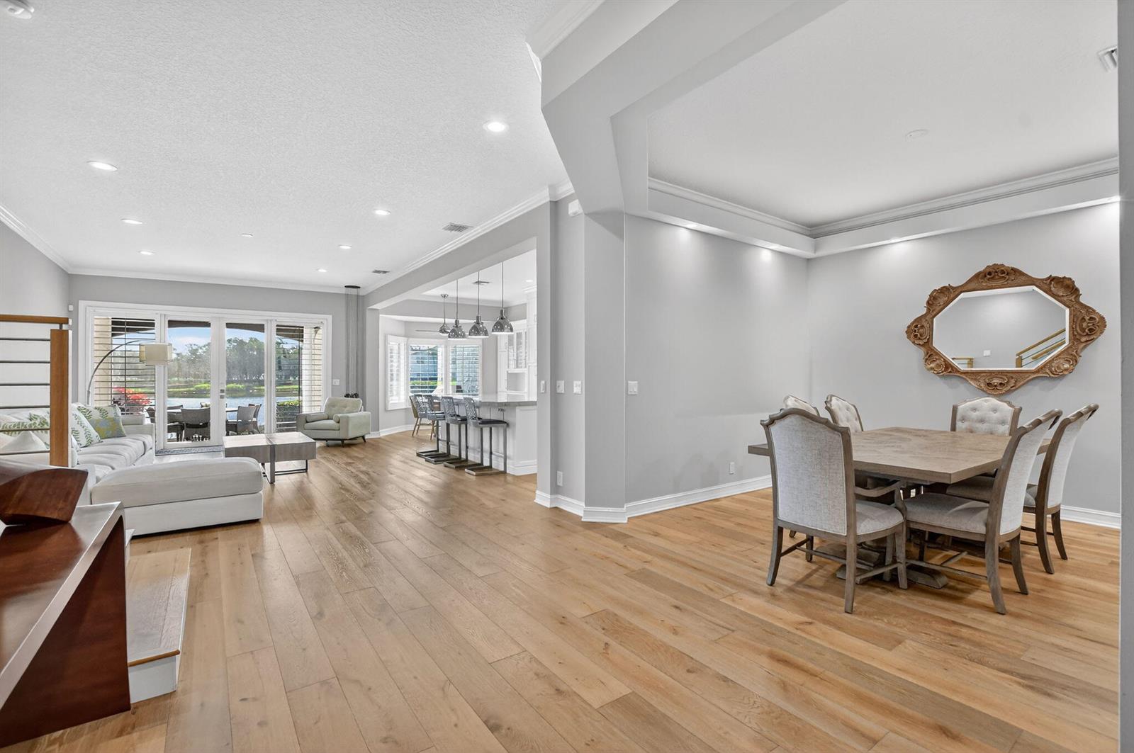An open-concept living and dining area with light wood floors and a view of water — 1535 Estuary Trail, Delray Beach FL 33483, DELRAY BEACH, FL