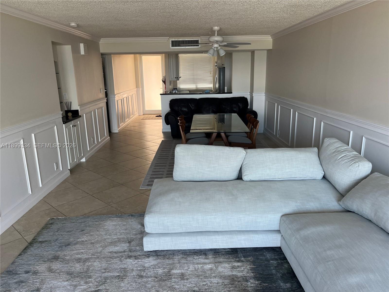A living room features a sliding glass door opening to a balcony overlooking the ocean — 510 N Ocean Blvd # 211, Pompano Beach FL 33062, POMPANO BEACH, FL