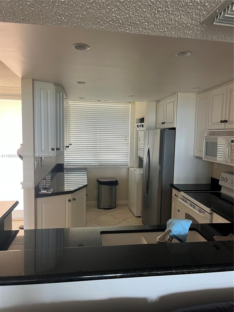 A living and dining area features a sectional sofa, glass dining table, and wainscoting — 510 N Ocean Blvd # 211, Pompano Beach FL 33062, POMPANO BEACH, FL