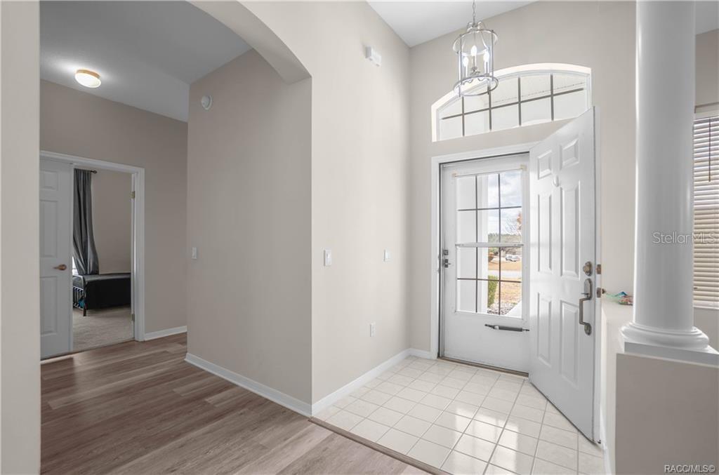 An entryway with tile flooring, a white front door, and a view into a room — 389 W HILLMOOR LANE, BEVERLY HILLS, FL