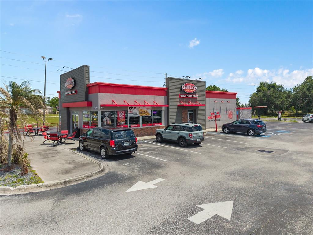 A Charleys Philly Steaks restaurant exterior with a parking lot and outdoor seating area — 3250 W VINE STREET, KISSIMMEE, FL