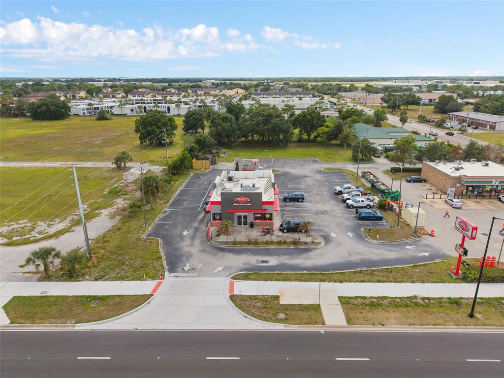 An aerial view shows a Charley's restaurant with a parking lot next to a road — 3250 W VINE STREET, KISSIMMEE, FL
