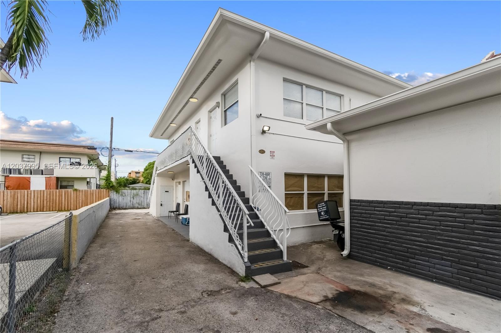 A two-story white building features an exterior staircase leading to an upper-level balcony — 1131 SW 7th St, Miami FL 33130, MIAMI, FL