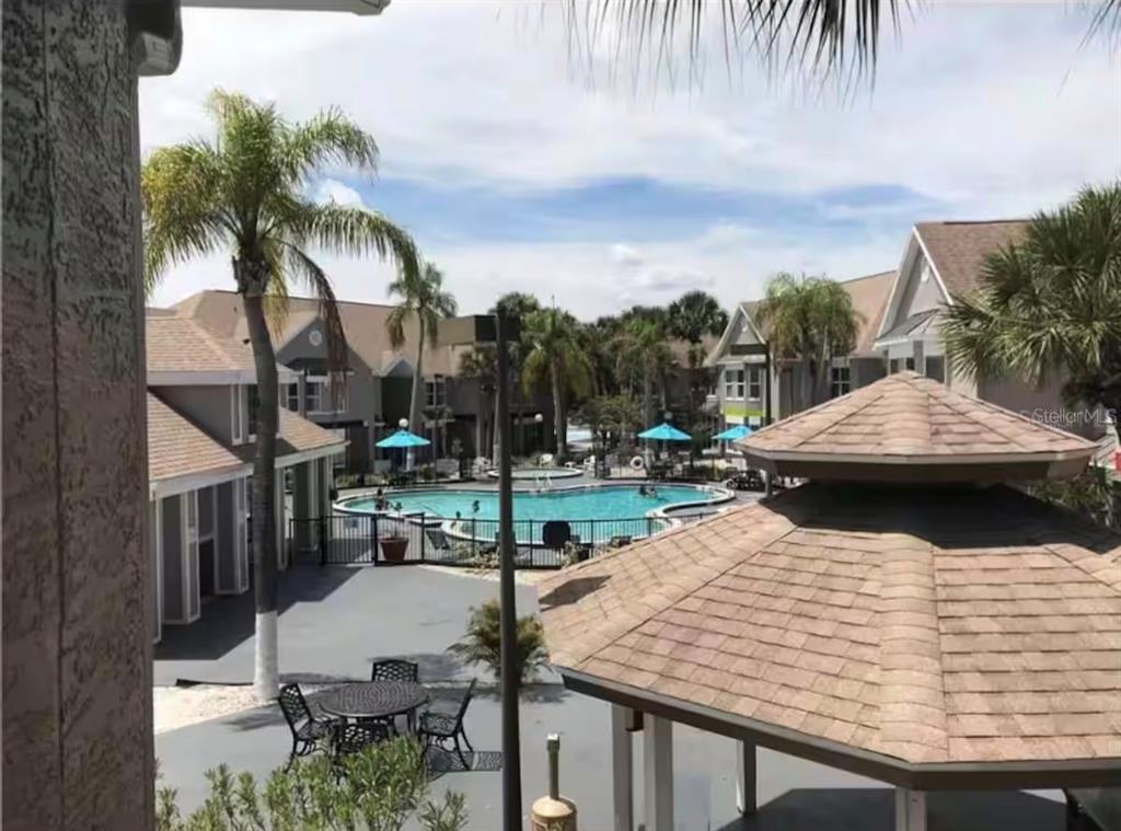An elevated view of a swimming pool area surrounded by apartment buildings and a gazebo — 3100 PARKWAY BOULEVARD UNIT 422, KISSIMMEE, FL