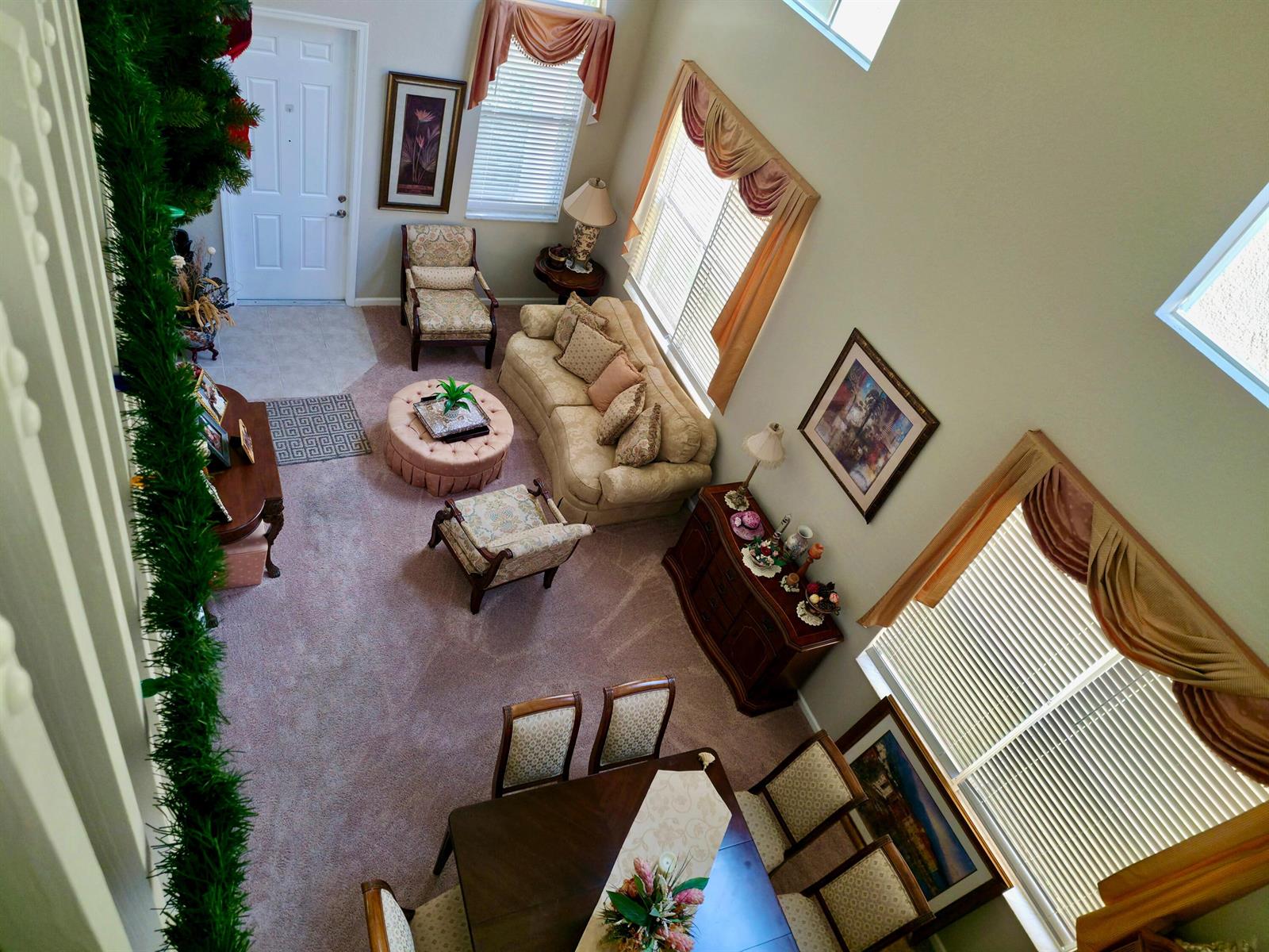 An elevated view of a living and dining area with carpeted floors and high ceilings — 236 Gazetta Way, West Palm Beach FL 33413, WEST PALM BEACH, FL
