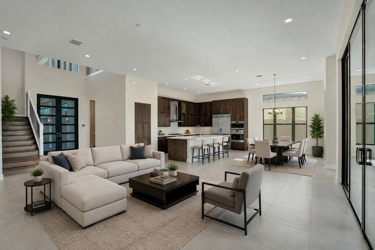 An open-concept living room and kitchen featuring dark wood cabinetry, a large island, and stairs — 9547 Riverside Park Drive, Boca Raton FL 33434, BOCA RATON, FL