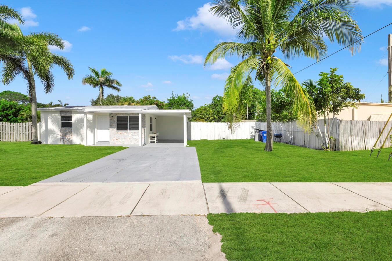 A single-story house with a white exterior, a carport, and a palm tree-lined front yard — 2533 NE 12th Terrace, Pompano Beach FL 33064, POMPANO BEACH, FL