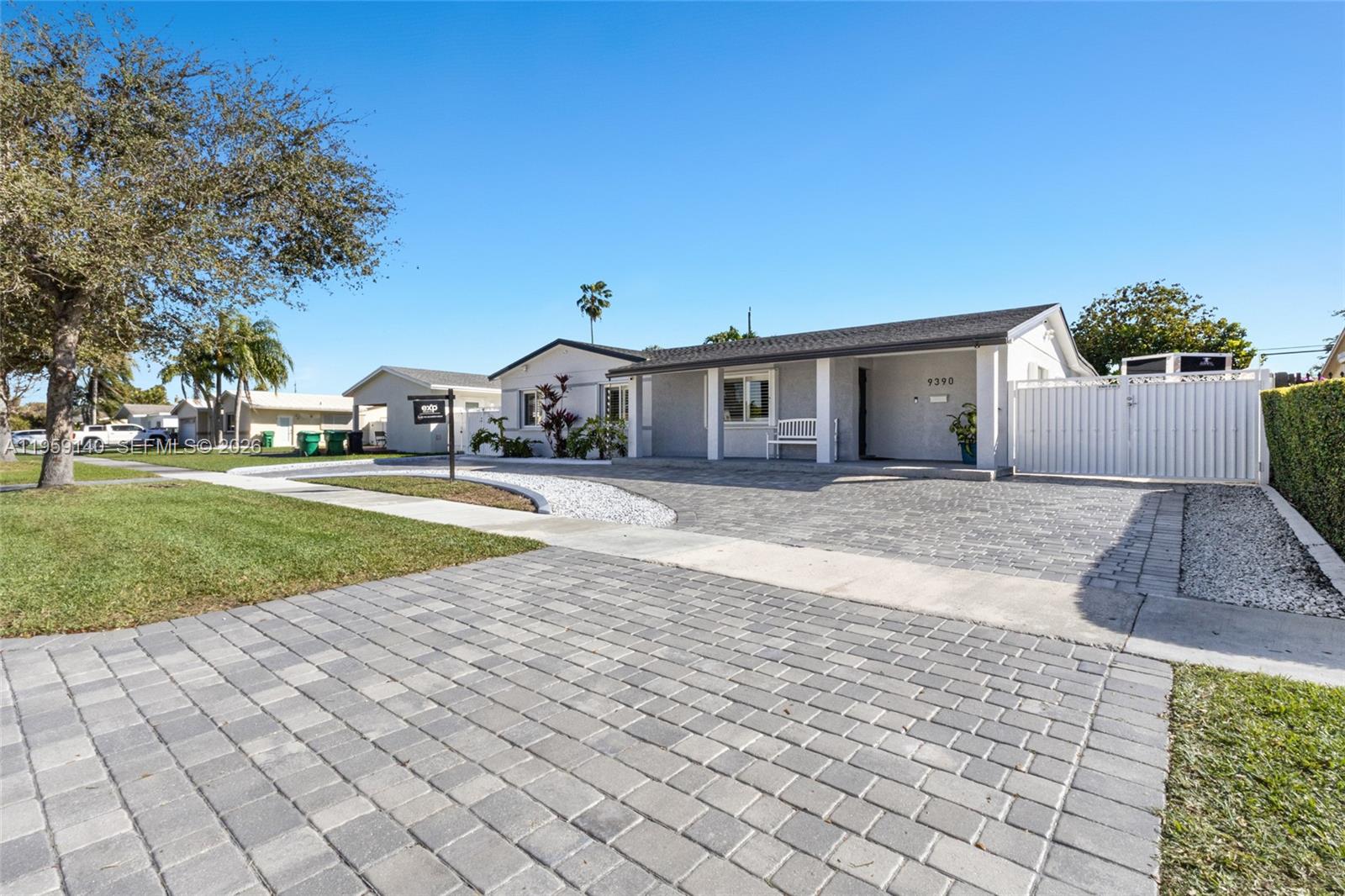 A single-story house with a paved driveway, white fence, and a small front porch — 9390 SW 190th St, Cutler Bay FL 33157, CUTLER BAY, FL