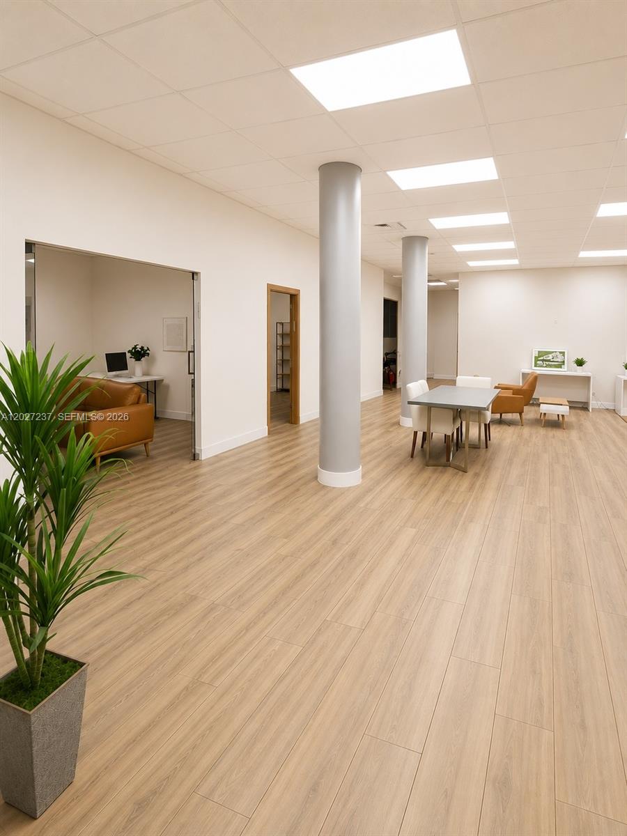 A modern office space features light wood flooring, two structural columns, and recessed ceiling lighting — 3505 S Ocean Dr, Hollywood FL 33019, HOLLYWOOD, FL