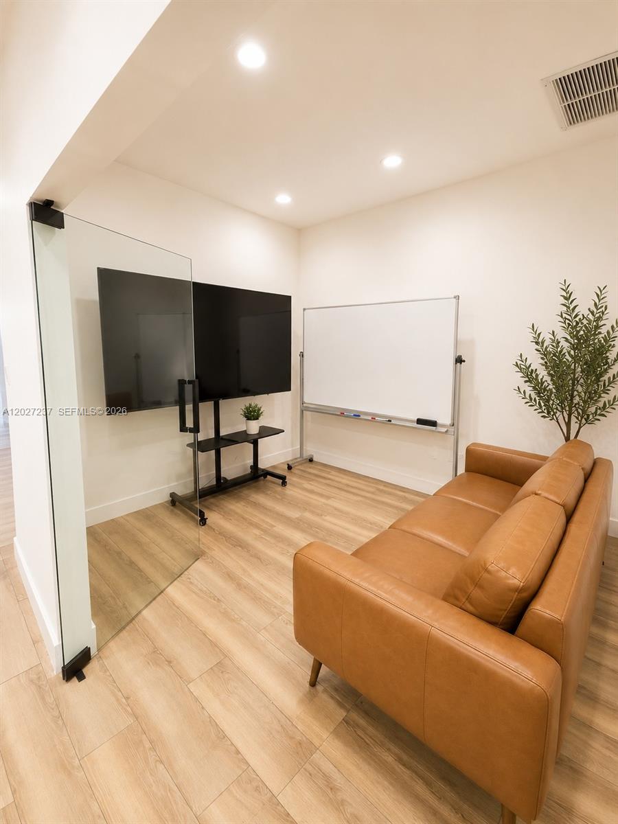 A small office room features a leather sofa, a television on a stand, and a whiteboard — 3505 S Ocean Dr, Hollywood FL 33019, HOLLYWOOD, FL