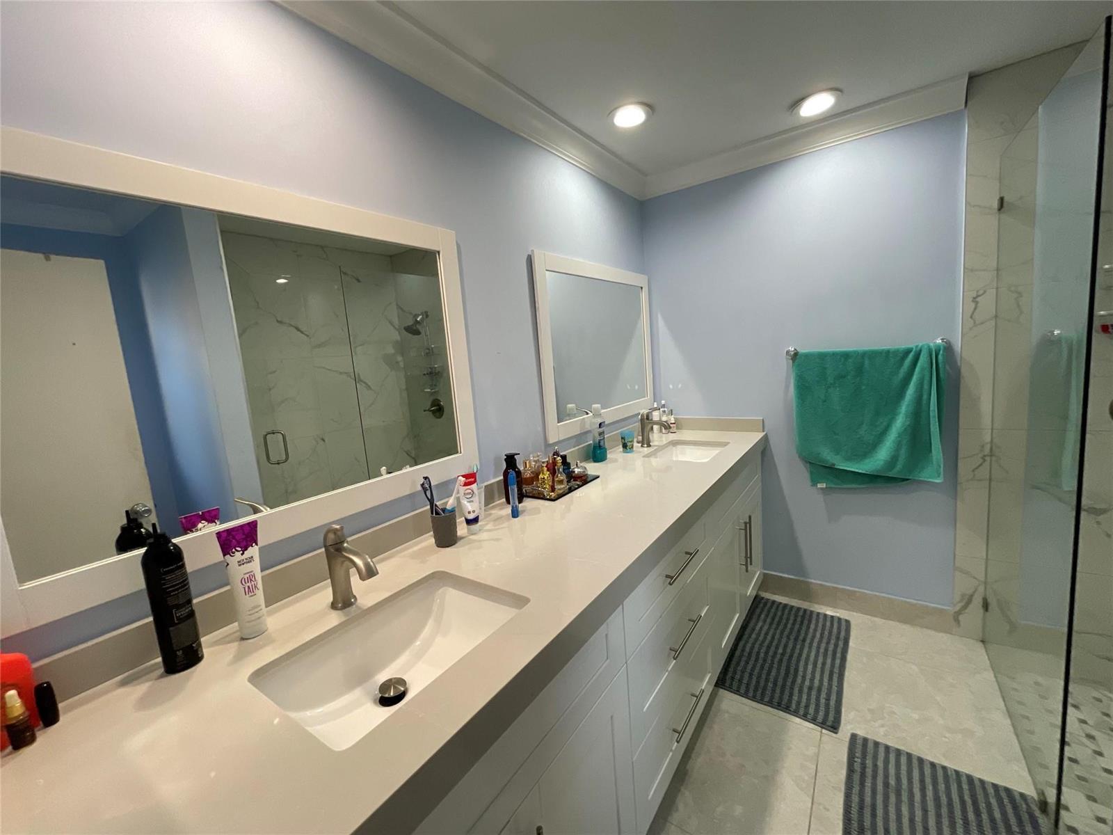 A bathroom features a double vanity with white cabinets, quartz countertops, and two framed mirrors — 9020 Pine Springs Drive, Boca Raton FL 33428, BOCA RATON, FL