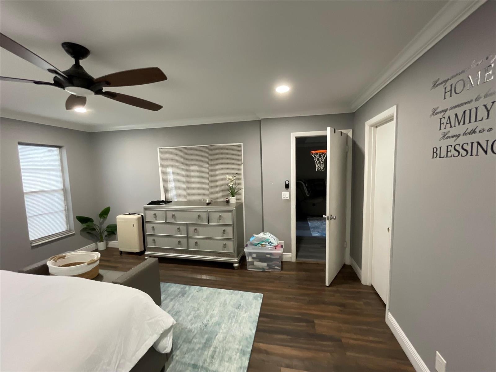 A bedroom with grey walls, dark wood flooring, a ceiling fan, and a dresser — 9020 Pine Springs Drive, Boca Raton FL 33428, BOCA RATON, FL