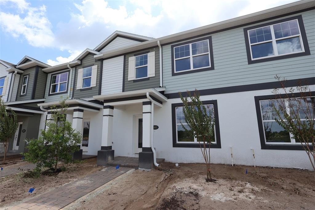 A modern kitchen features white cabinetry, a large center island, and light-colored tile flooring — 1417 HYDE STREET, ST CLOUD, FL