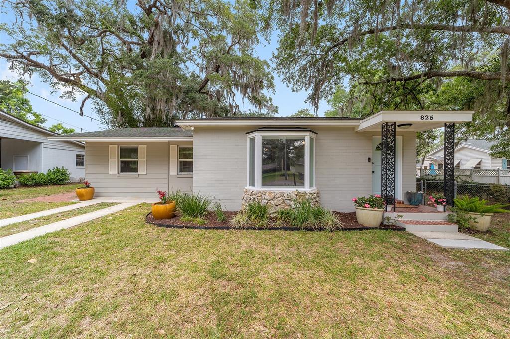 A single-story house with a light gray brick exterior, a bay window, and a front porch — 825 SE 13TH STREET, OCALA, FL