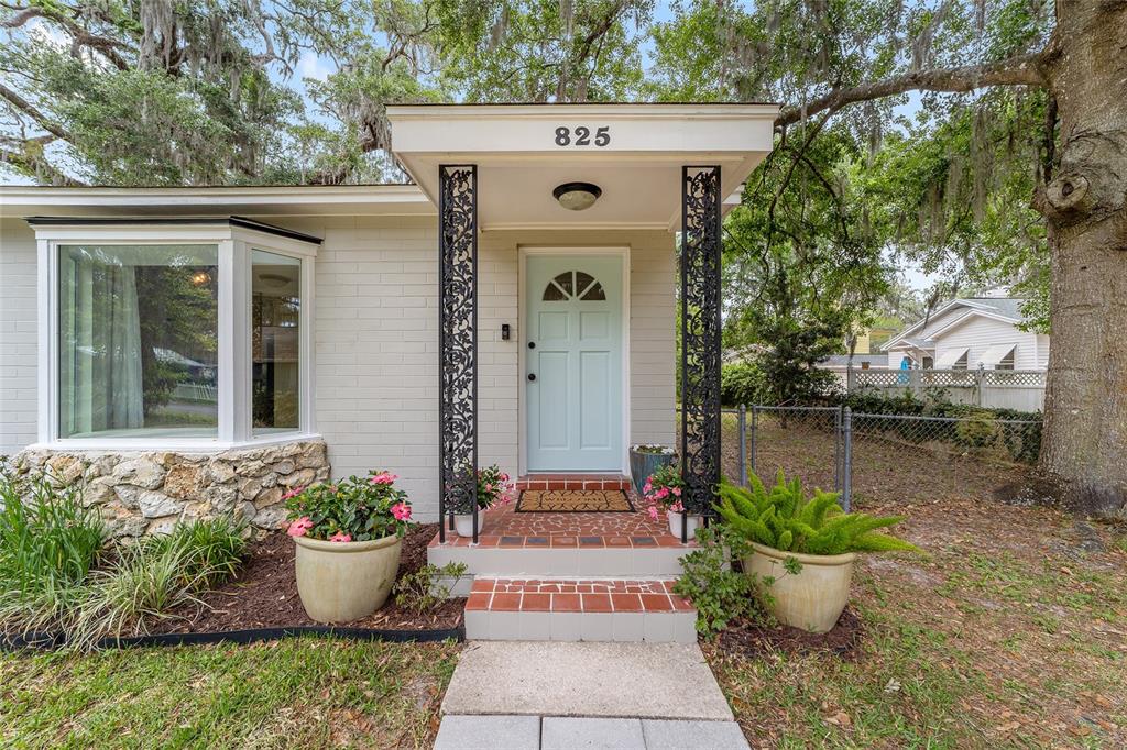 The exterior of a house features a light blue front door, decorative iron columns, and stone accents — 825 SE 13TH STREET, OCALA, FL