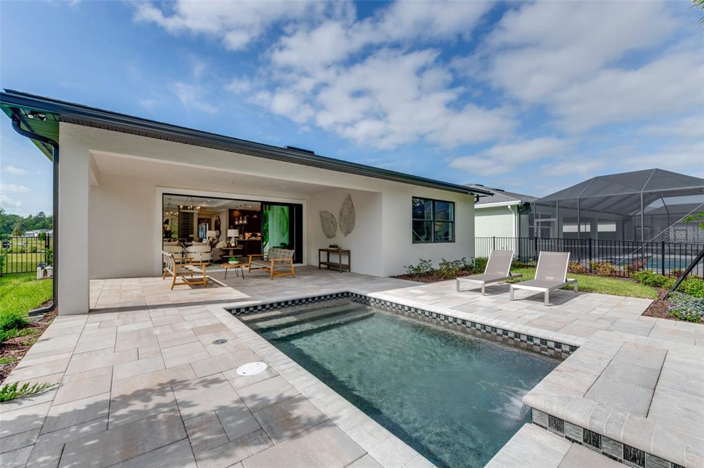 A backyard patio features a small rectangular swimming pool, lounge chairs, and a covered lanai — 1193 CRESSWIND BOULEVARD, DELAND, FL