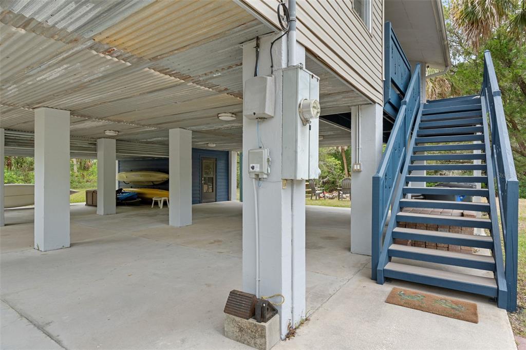 The ground level of a stilt house features a concrete patio, support columns, and stairs — 2272 S TODD POINT, HOMOSASSA, FL