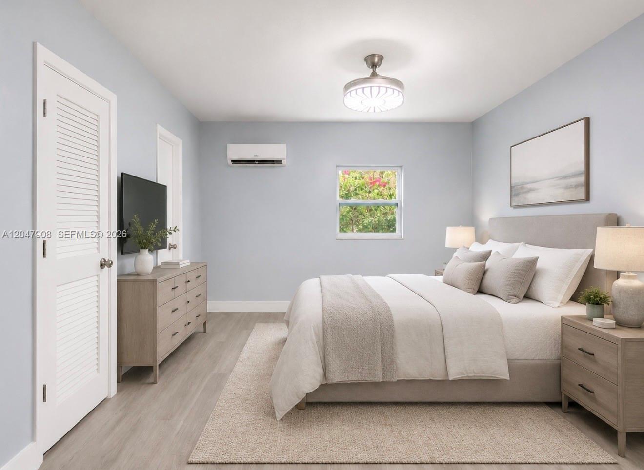 This bedroom features light blue walls, a bed with neutral bedding, and a wood dresser — 432 NW 103rd St # 2, Miami FL 33150, MIAMI, FL