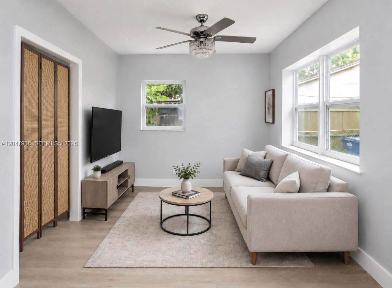 A living room features a light-colored sofa, a round coffee table, and a ceiling fan — 432 NW 103rd St # 2, Miami FL 33150, MIAMI, FL