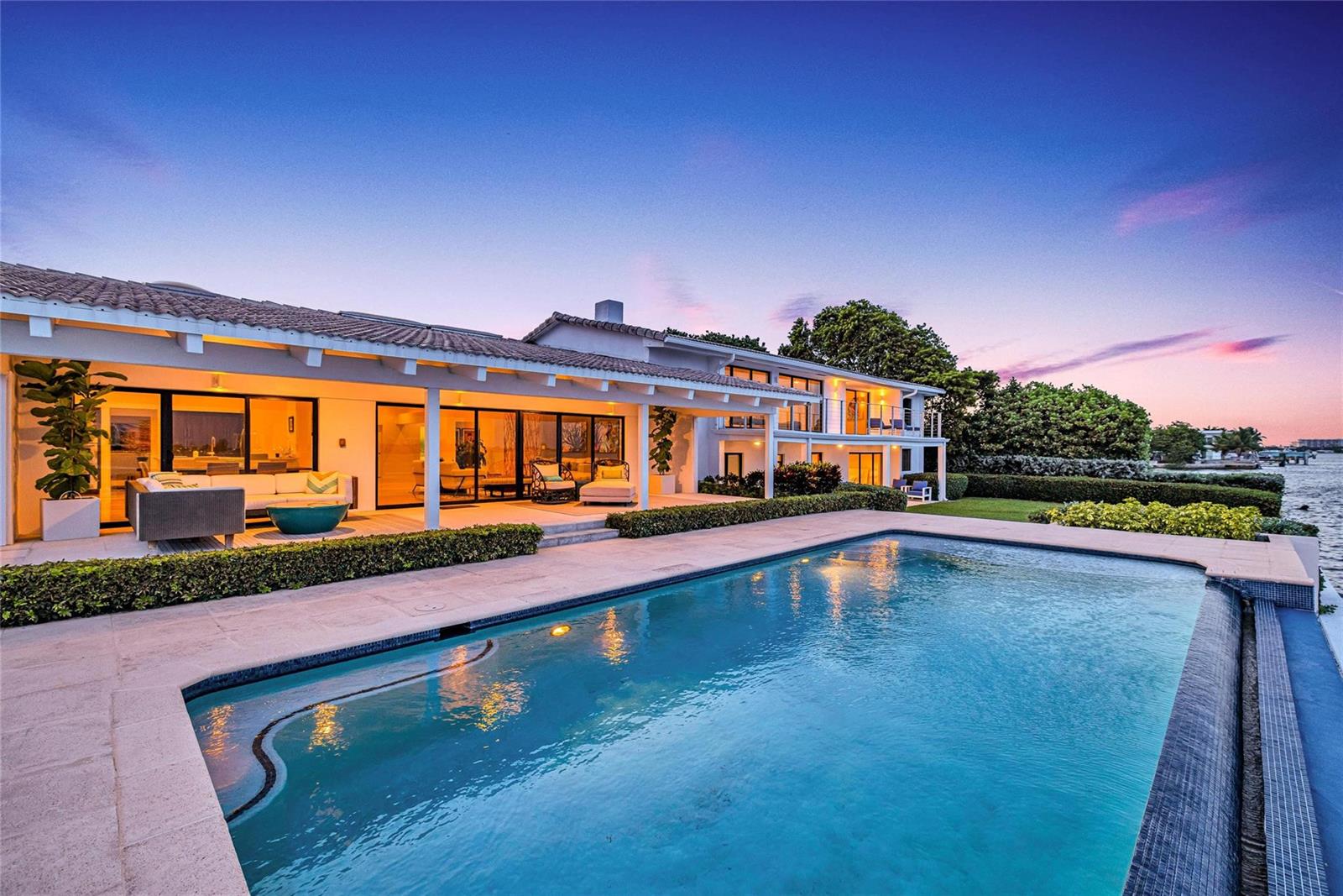A modern waterfront house features a swimming pool, a covered patio, and large glass doors — 1290 NE 83rd Street, Miami FL 33138, MIAMI, FL