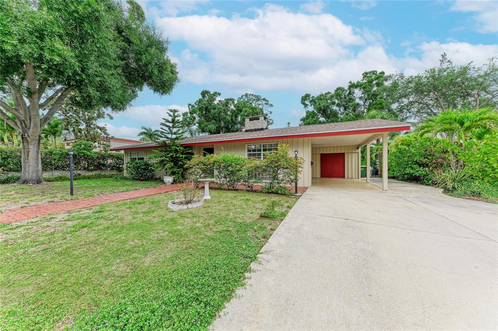 A single-story house with a carport, red trim, and a brick walkway on a lawn — 1827 ALTA VISTA STREET, SARASOTA, FL