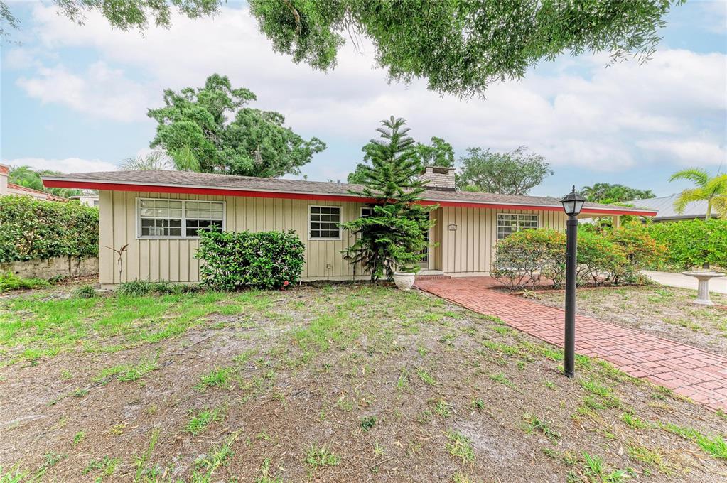 A single-story house with tan vertical siding, a red trim, and a brick walkway — 1827 ALTA VISTA STREET, SARASOTA, FL