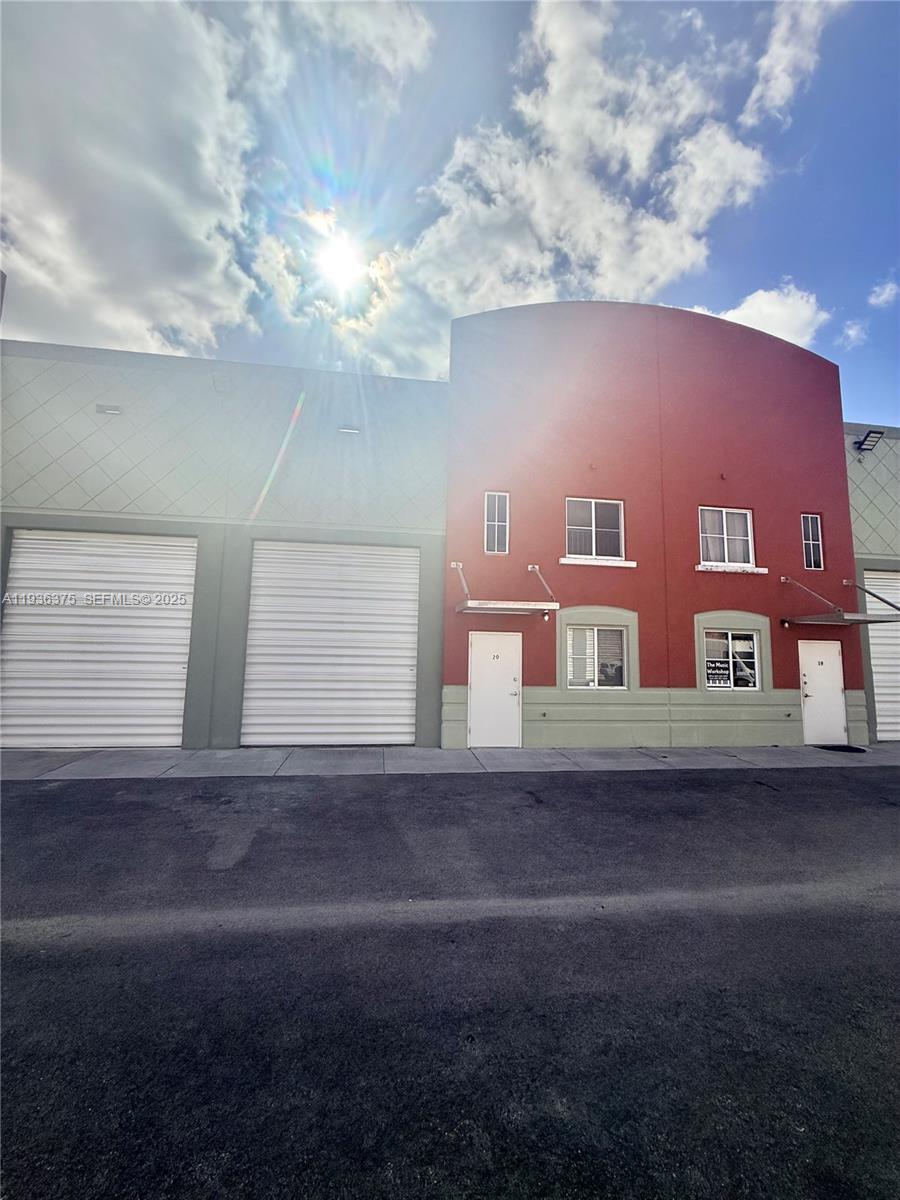 A red and gray commercial building features two roll-up doors and two ground-level entry doors — 12491 SW 134th Ct # 20, Miami FL 33186, MIAMI, FL
