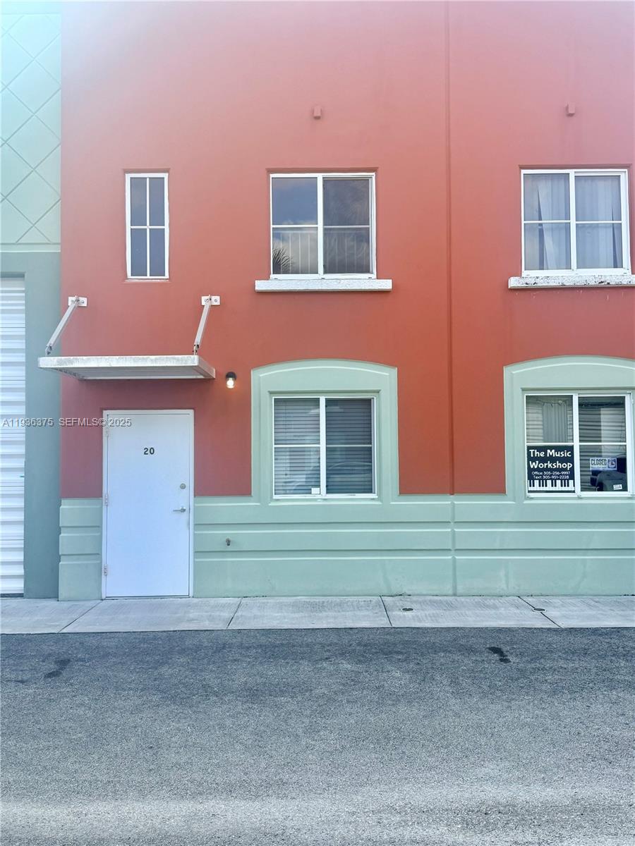 The exterior of a two-story building features a white door, windows, and orange-painted walls — 12491 SW 134th Ct # 20, Miami FL 33186, MIAMI, FL