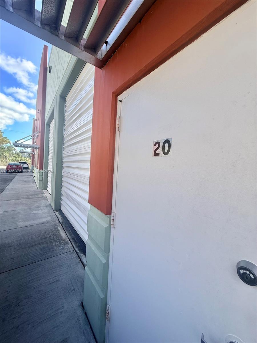 A white door labeled with the number 20 stands beside a metal roll-up door — 12491 SW 134th Ct # 20, Miami FL 33186, MIAMI, FL