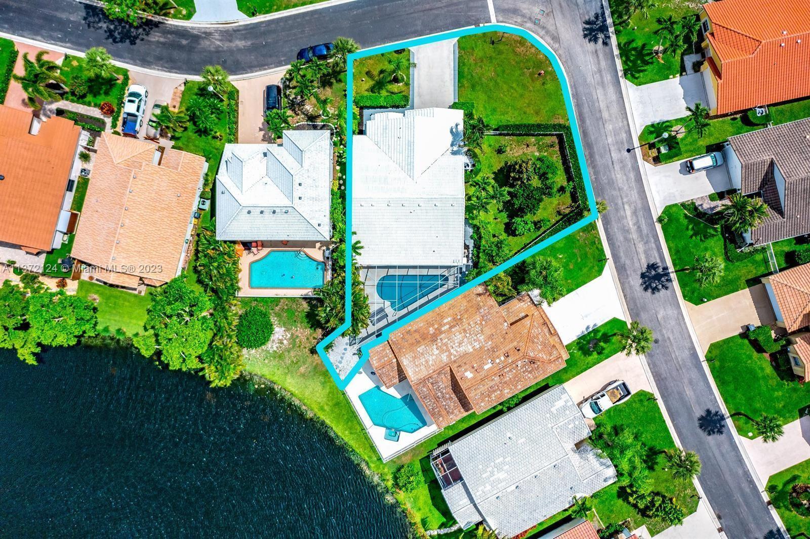 A single-story house with a white tile roof, a two-car garage, and a palm tree — 2690 Linkside Drive, Wellington FL 33414, WELLINGTON, FL