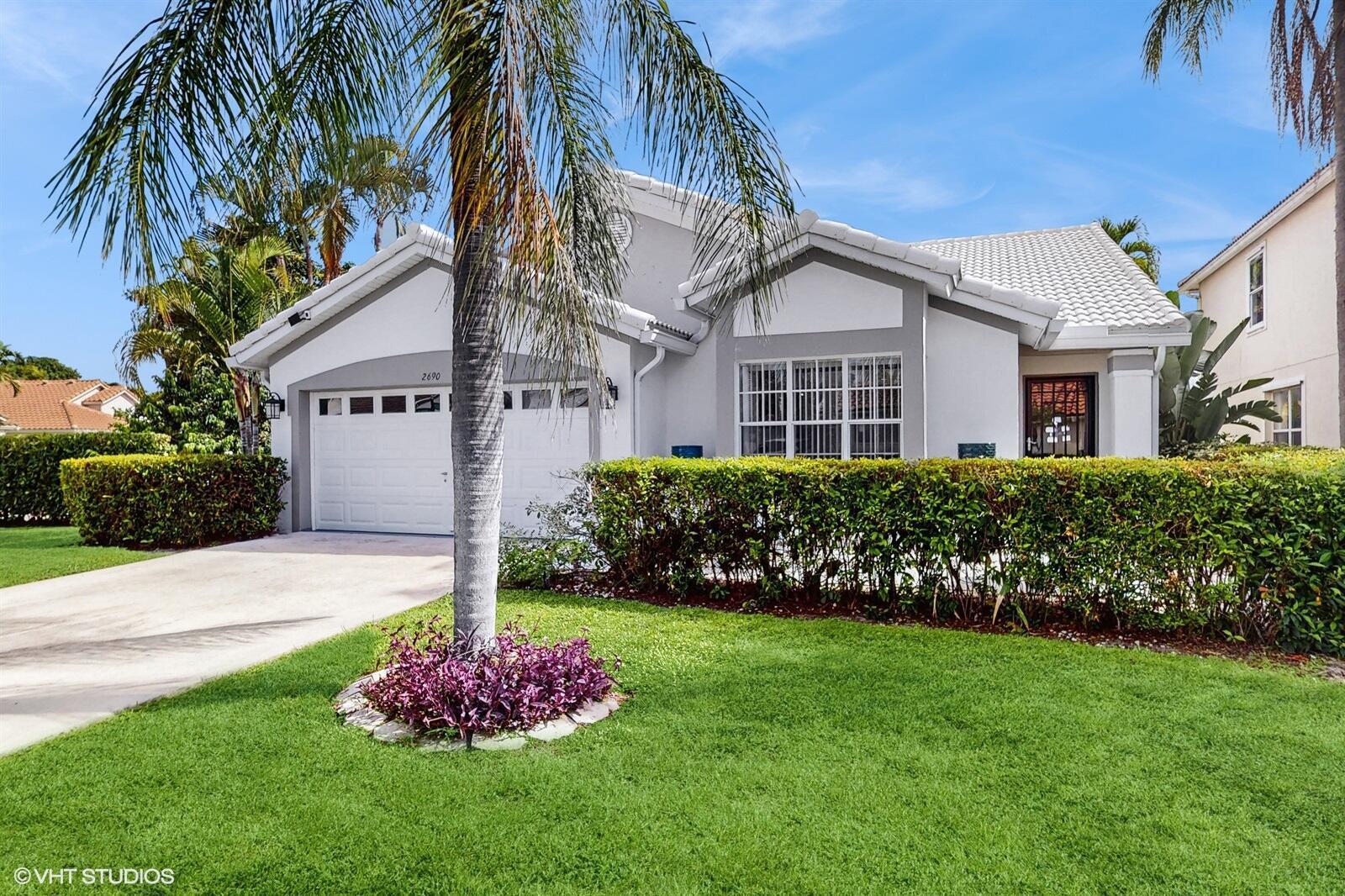 A single-story house with a white tiled roof, gray trim, and a manicured hedge — 2690 Linkside Drive, Wellington FL 33414, WELLINGTON, FL