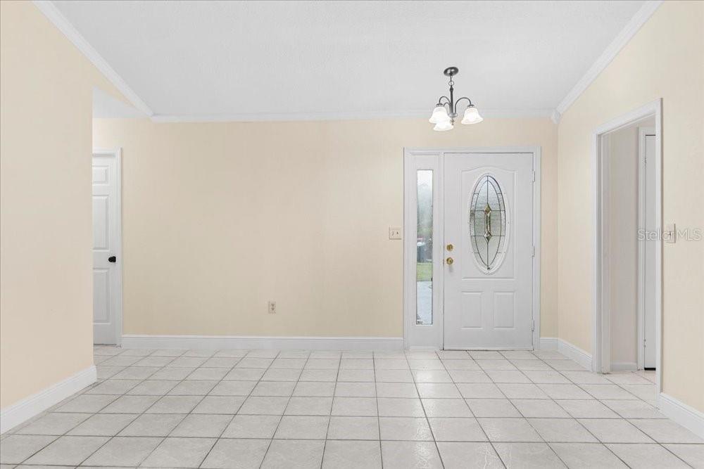 A tiled entryway features a white front door with an oval glass insert — 4768 CROSSBOW COURT, ORLANDO, FL