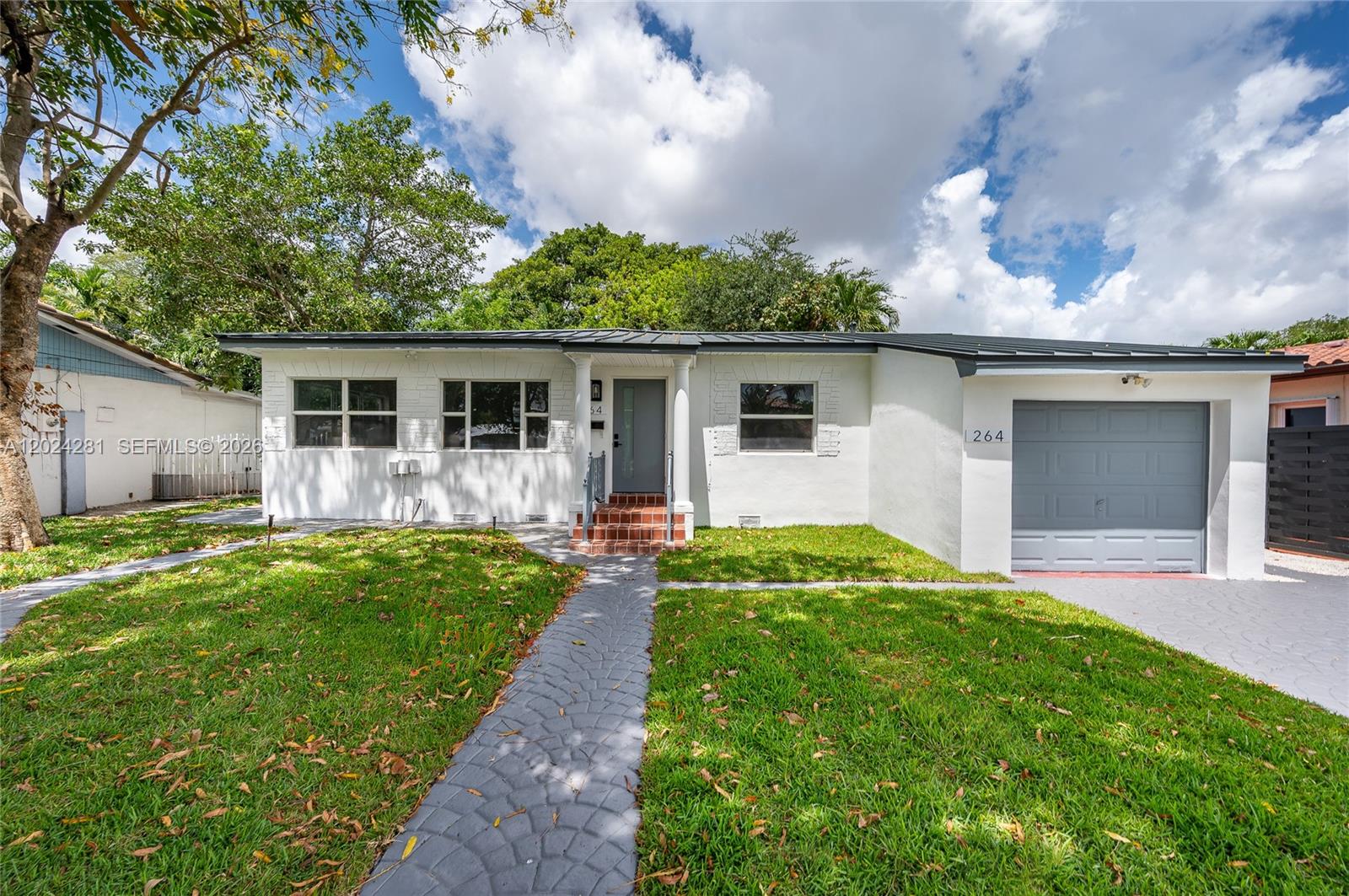 A single-story white house with a gray garage door and a paved walkway — 264 Navajo St, Miami Springs FL 33166, MIAMI SPRINGS, FL