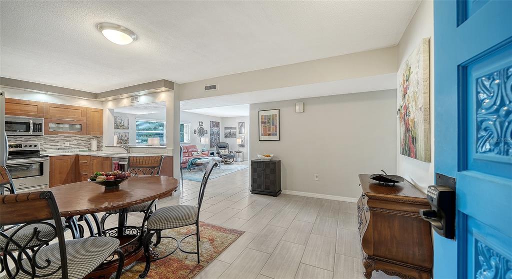 A dining area with tile floors leads into a kitchen and a living room — 225 HOURGLASS WAY UNIT 202, SARASOTA, FL