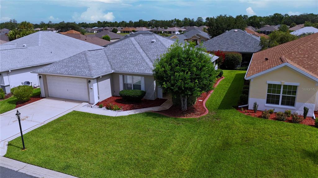 An aerial view shows a suburban house with a gray roof and a green lawn — 11981 SE 91ST CIRCLE, SUMMERFIELD, FL